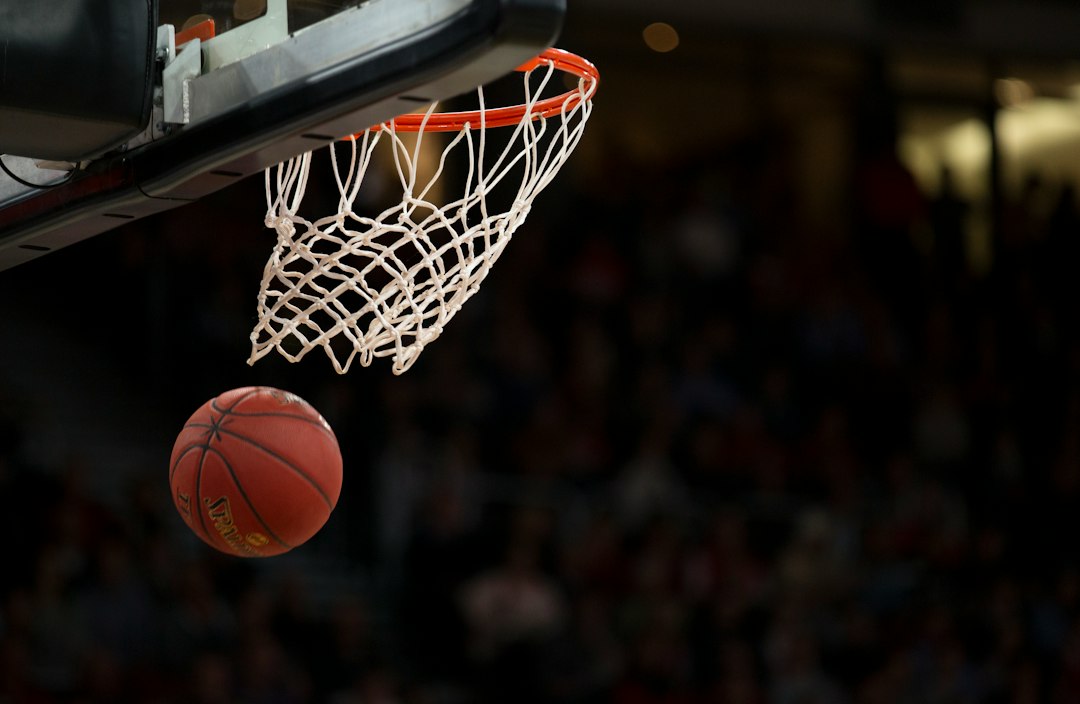 Balón de baloncesto sobre el parquet bajo el aro del tablero